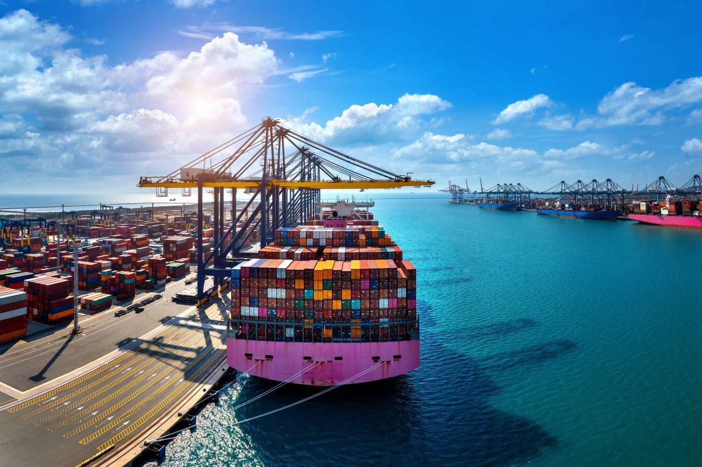 Container ship loaded at a port with cranes and stacked containers